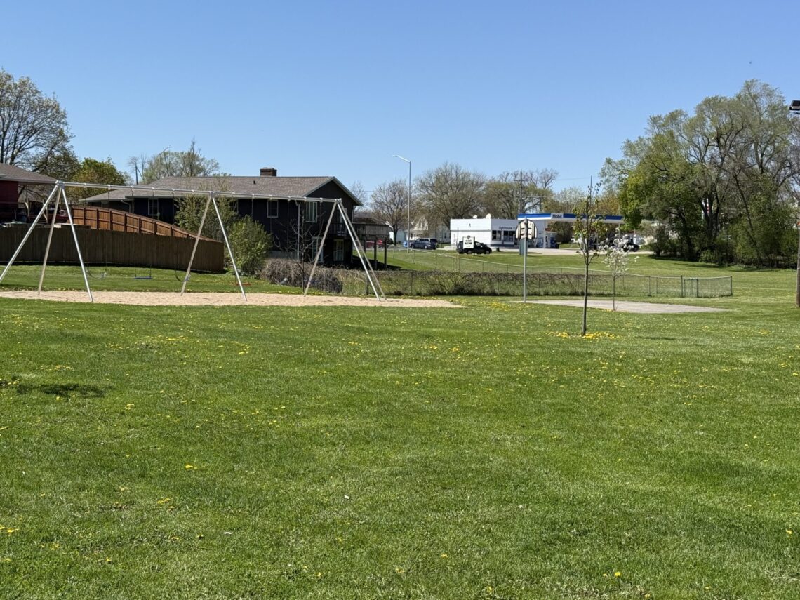 Picture of a swing set and a half basketball court