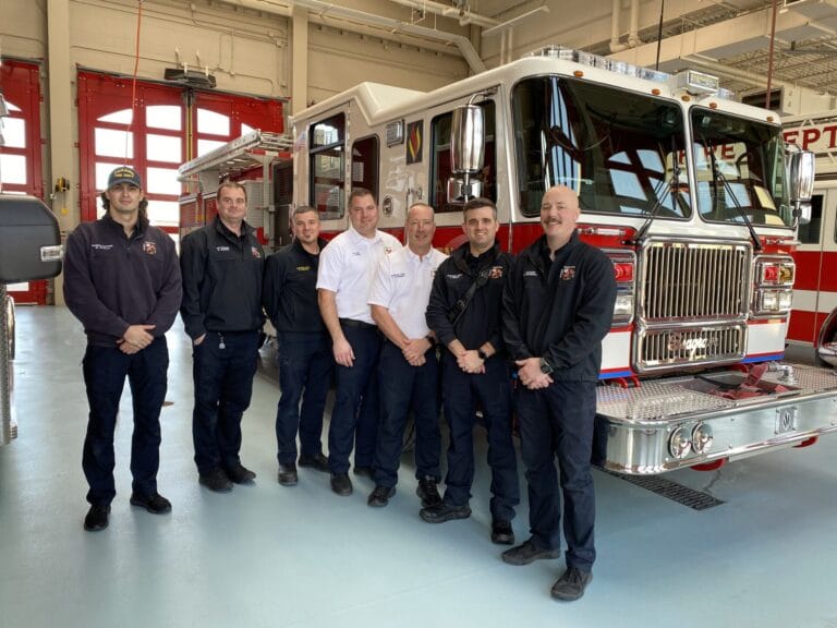 Fire Department Staff stand beside fire truck