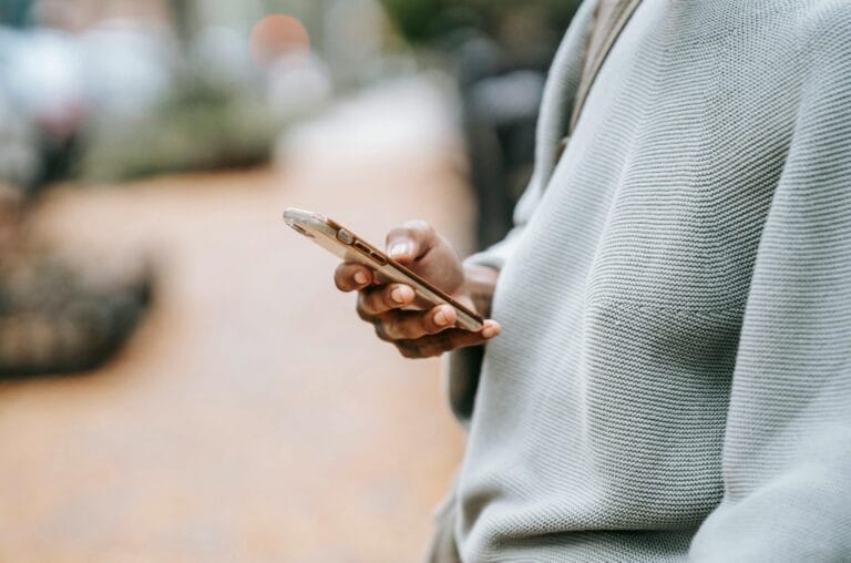Stock image of a person holding a phone by Tim Samuel