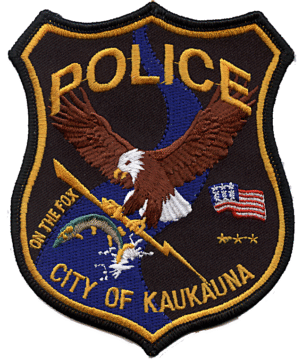 Kaukauna police department badge featuring an eagle holding a lightning bolt reaching for a fish.